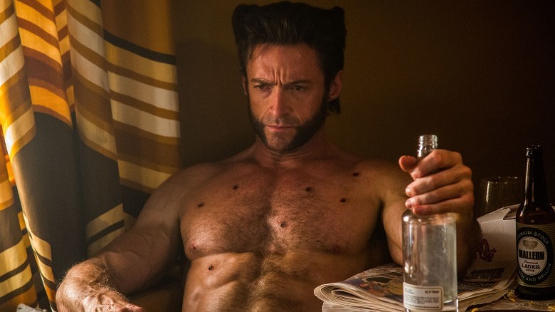 Wolverine sitting down holding bottle