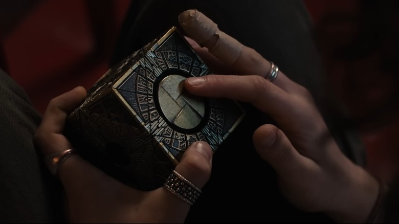 Riley's hand touching the puzzle box