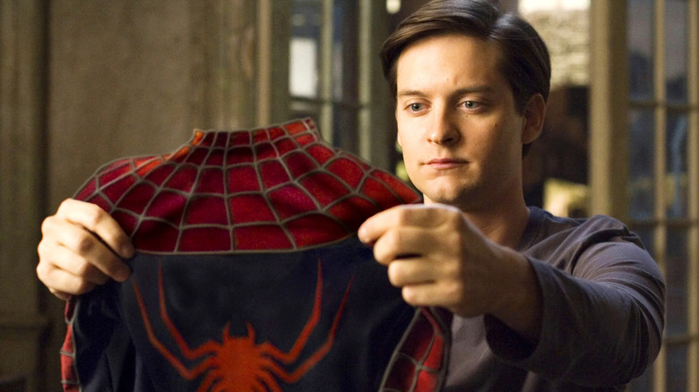 Peter Parker holds Spider-Man suit