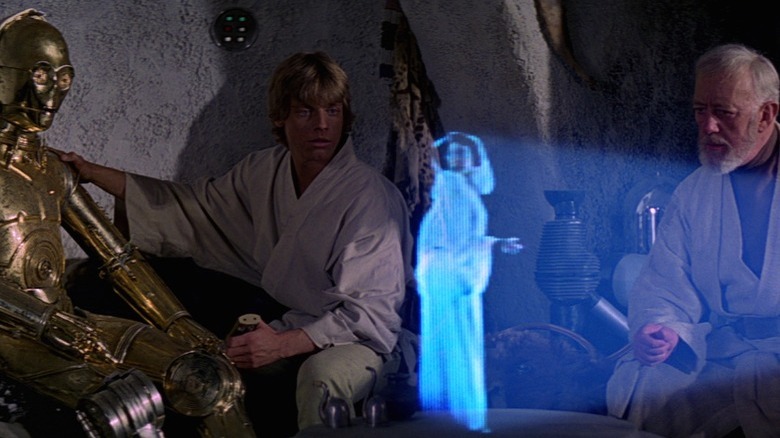 C-3PO, Luke, Obi-Wan watch Leia's hologram