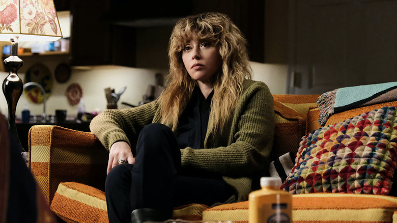 Natasha Lyonne sitting on couch