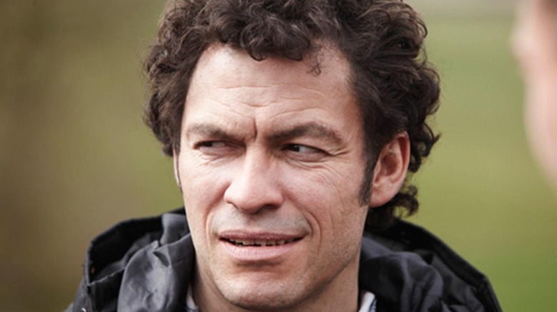 Dominic West looks to the side