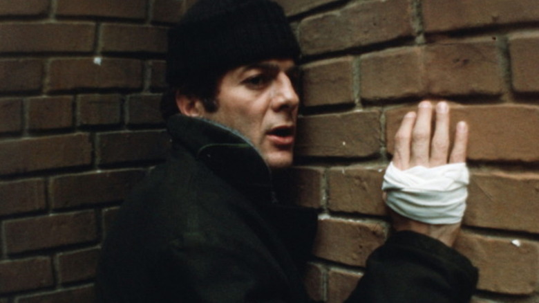 Tony Curtis leans against a wall