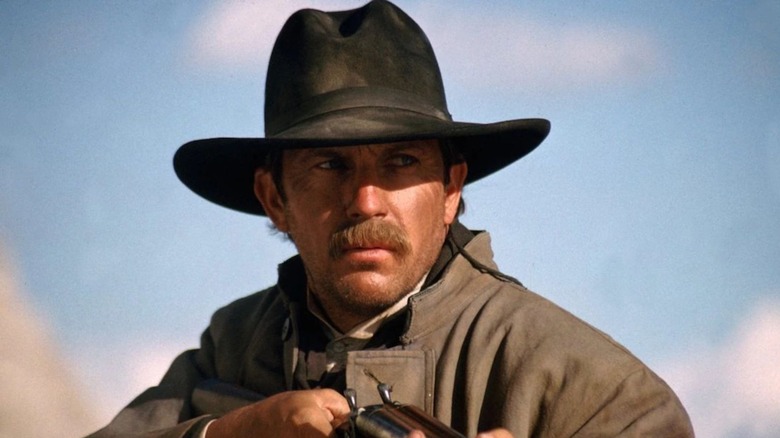 Kevin Costner holding a rifle