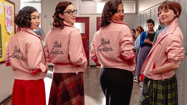 The Pink Ladies look over their shoulders smiling