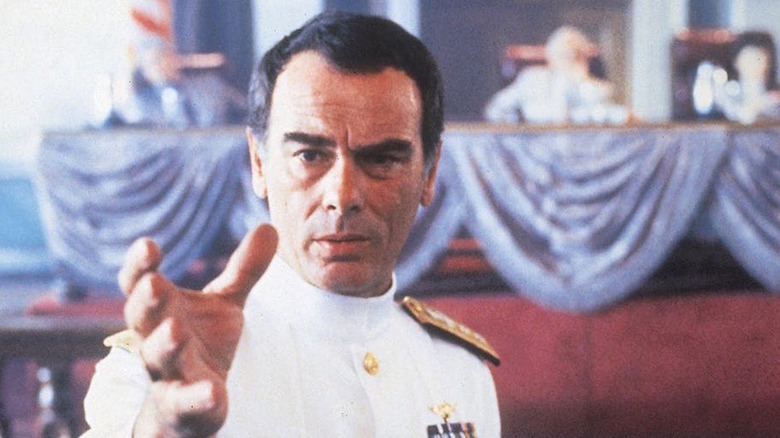 Dean Stockwell gestures with hand upraised