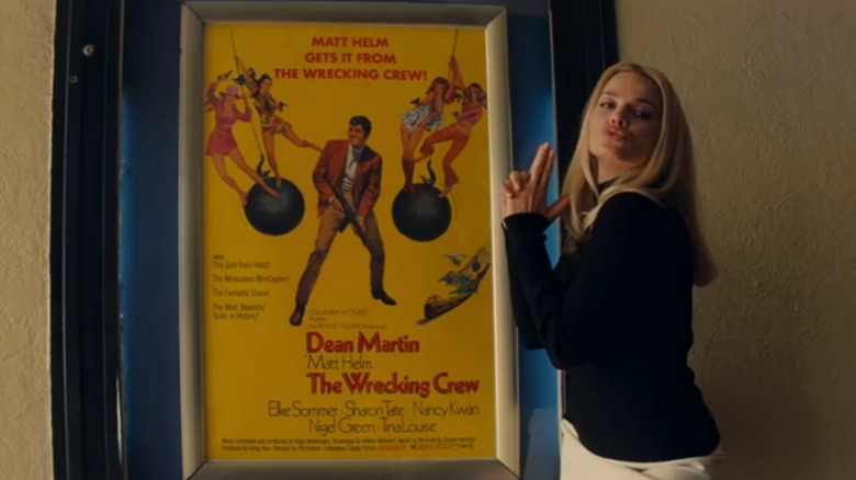 Sharon Tate poses next to movie poster