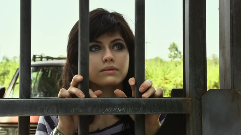 Alexandra Daddario peering through a gate