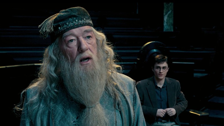 Dumbledore speaking, Harry seated behind him