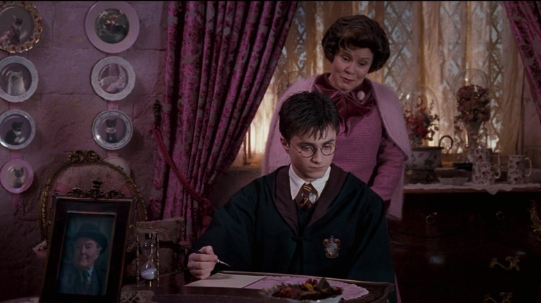 Harry Potter writing lines, Dolores Umbridge behind him