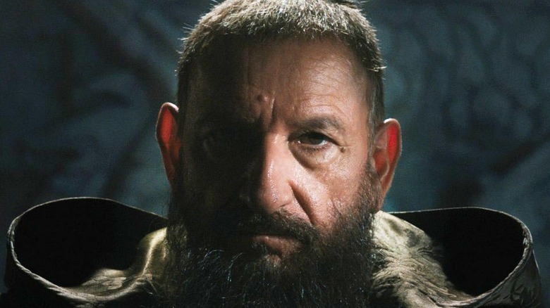 Trevor Slattery as the Mandarin sitting in shadows