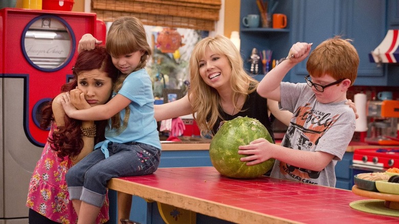 Sam, Cat, and kids carving a watermelon