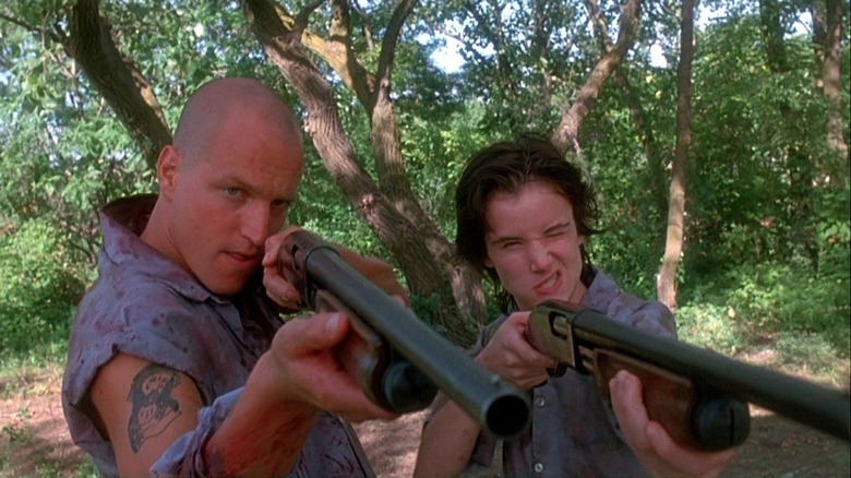 Woody Harrelson and Juliette Lewis holding shotguns