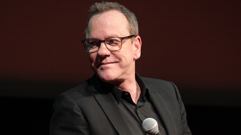 Kiefer Sutherland smiling and looking off to the side