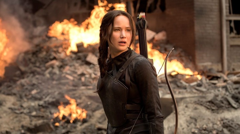 Katniss in front of burning building with quiver