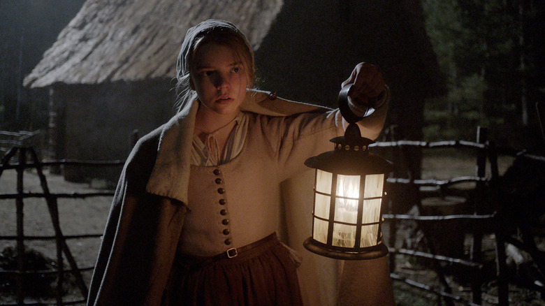 Anya Taylor-Joy holding a lamp in The Witch