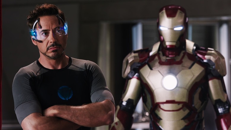 Tony Stark standing with Iron Man suit