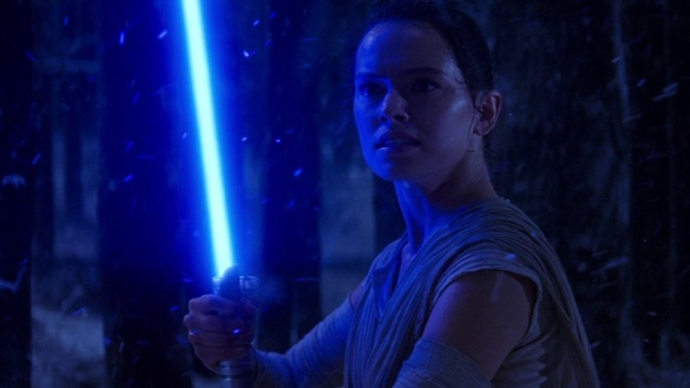 Rey holding lightsaber