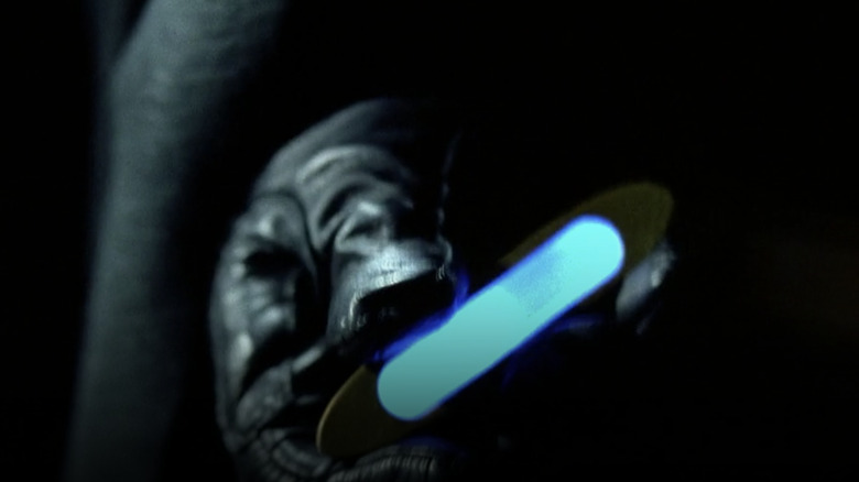 Gloved hand, glowing blue container