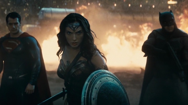 Superman, Wonder Woman, and Batman in front of fire