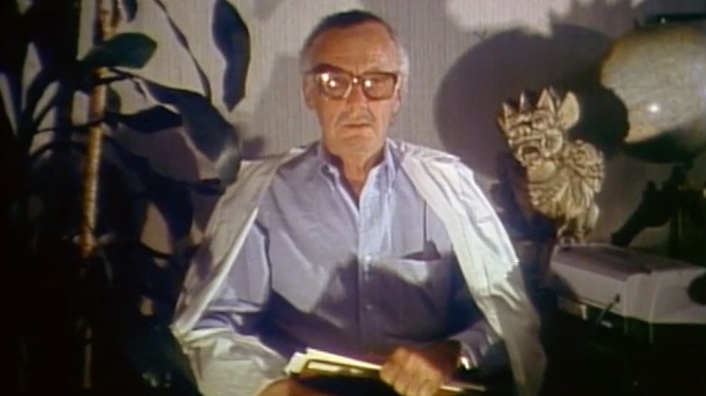 Stan Lee sits in an ominous room