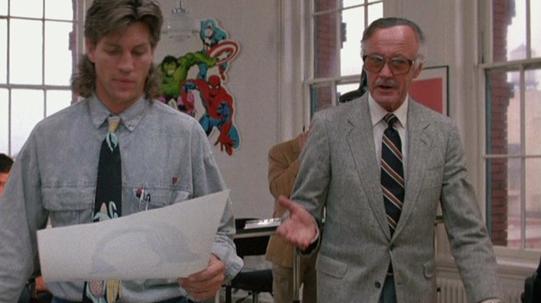 Stan Lee walks with Eric Roberts in an office