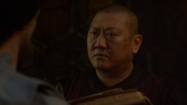 Benedict Wong holding books