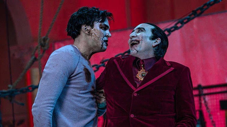 Dracula with bloody mouth laughs in Renfield's face