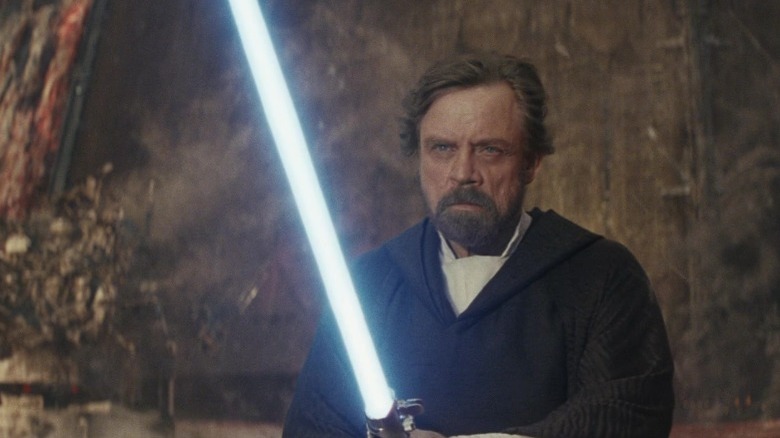 Luke Skywalker holds a lightsaber