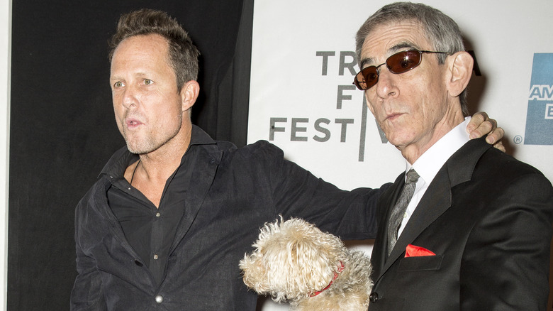 Dean Winters and Richard Belzer holding dog at event 