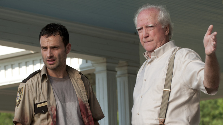 Hershel gestures out to Rick looking into distance