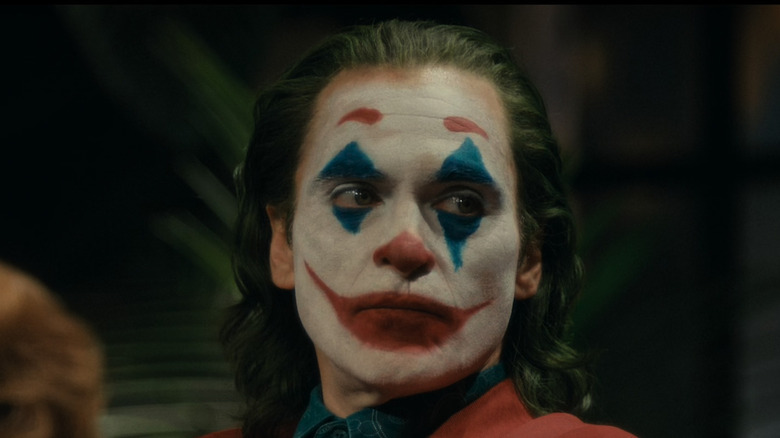 Arthur Fleck full clown makeup staring off to the side