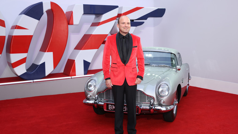 Rory Kinnear poses in front of a vintage car