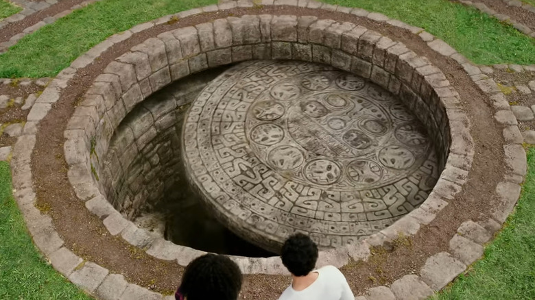 Noah and Elena look into a hole in the ground