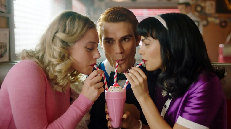 Three people drinking milkshakes