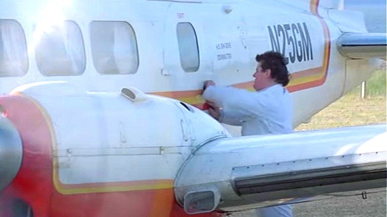 Man at airfield closing the airplane door