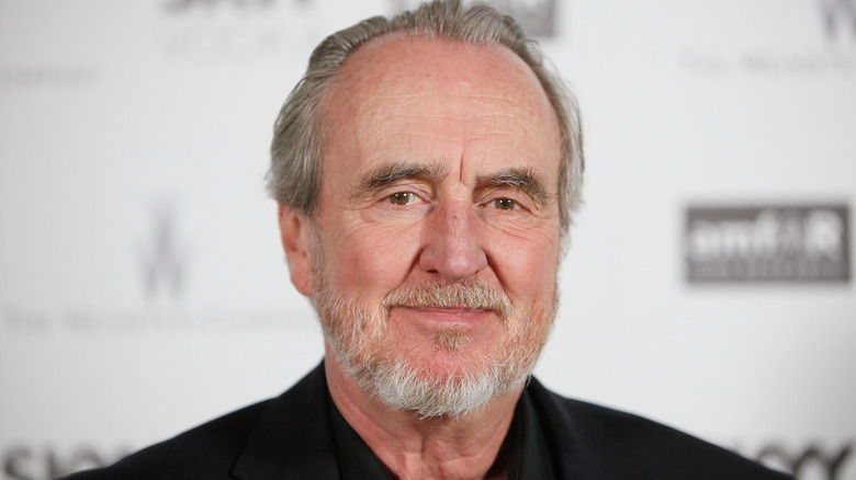 Wes Craven with closed smile grey hair and beard