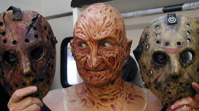 Freddy Krueger looking to left holding Jason masks