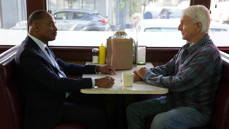 Rocky Carroll and Mark Harmon sitting in a diner