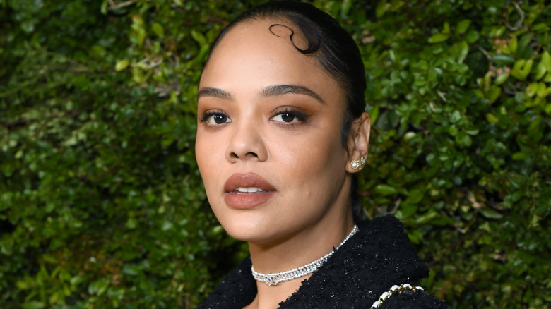 Tessa Thompson in front of bushes