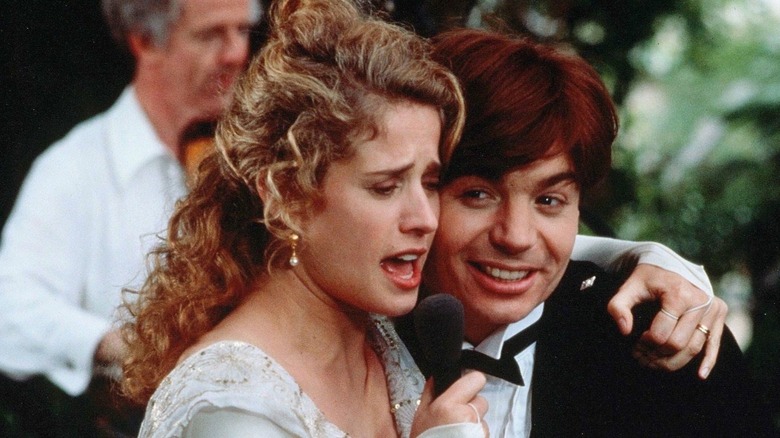 Mike Myers and Nancy Travis sing into microphone