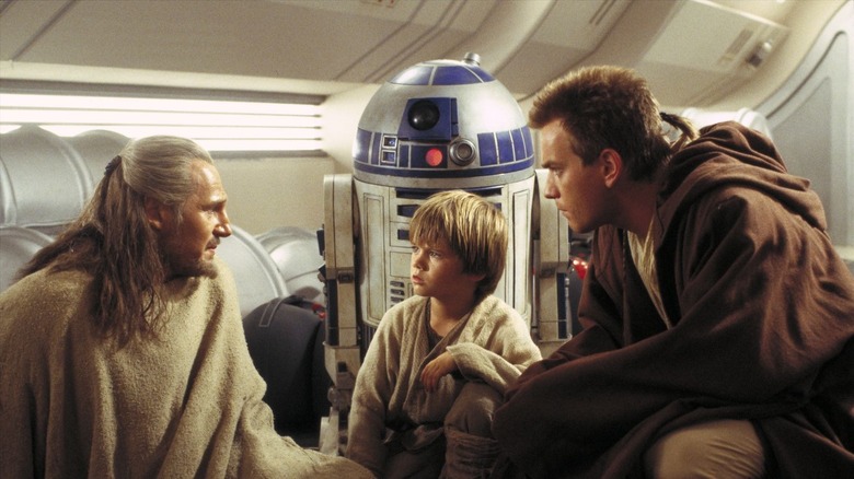 Liam Neeson talking to Jake Lloyd and Ewan McGregor