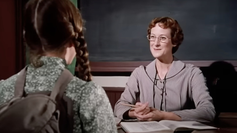 Mrs. Wilder talking to Laura from behind desk