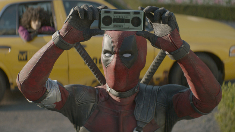 Deadpool holding a tiny boombox