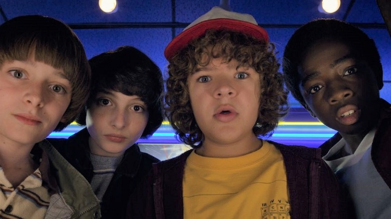 Dustin and his friends playing an arcade game in Stranger Things