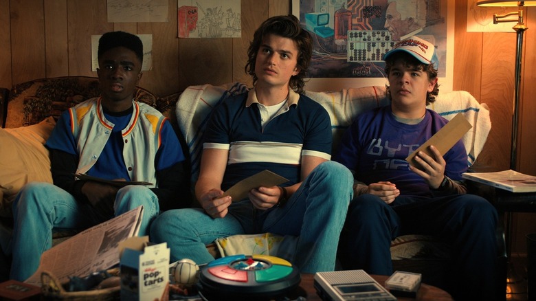 Lucas, Steve and Dustin sitting on a sofa in Stranger Things