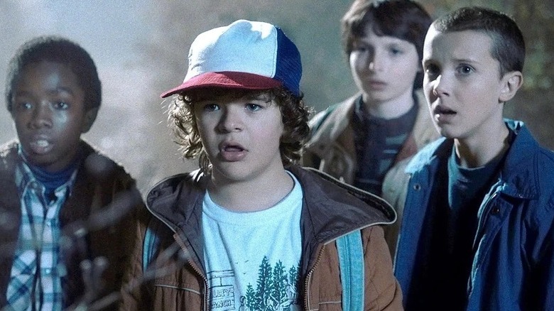 Lucas, Dustin, Mike and Eleven looking shocked and scared in Stranger Things