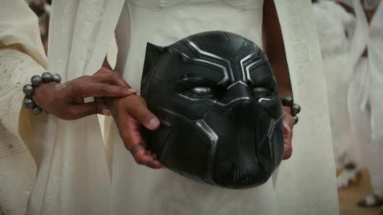 Shuri holding the Black Panther helmet