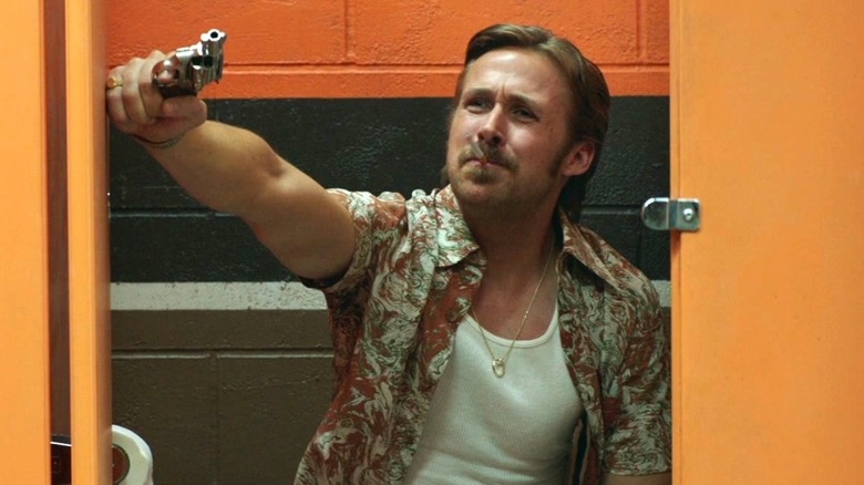 Ryan Gosling on toilet, points gun