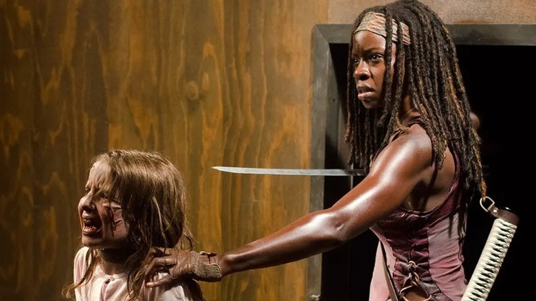 Michonne using her katana to hold off a walker